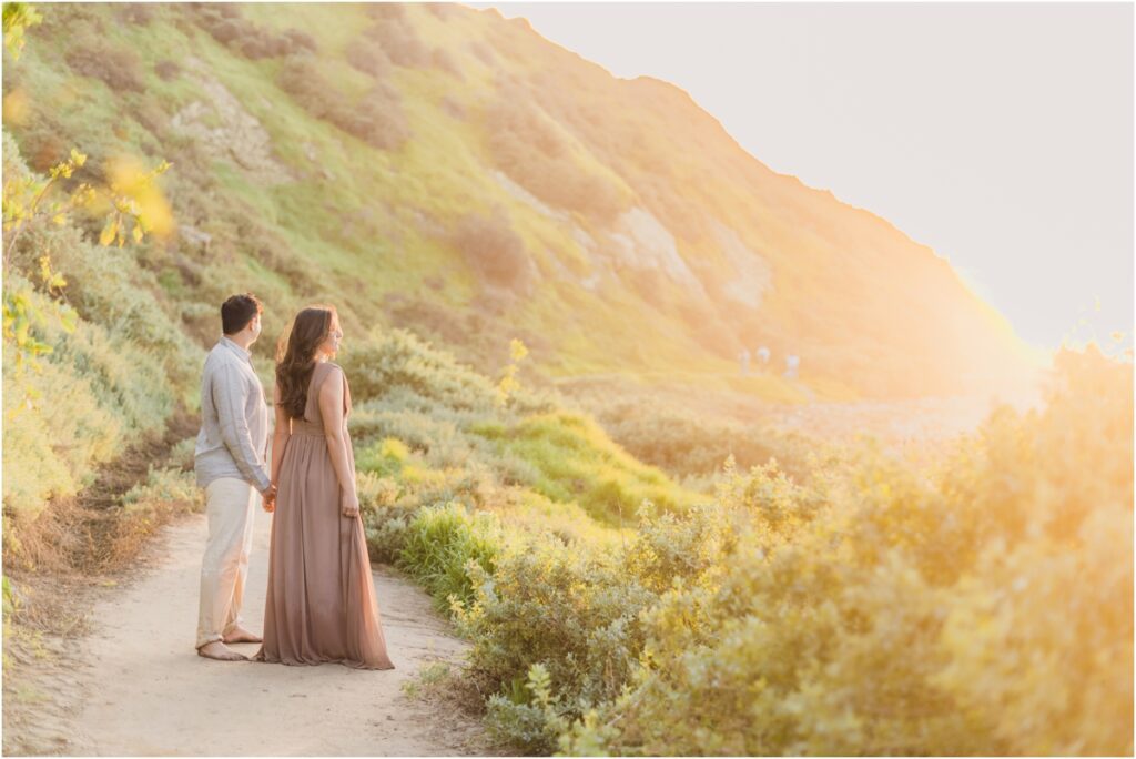 An engaged couple looks out at the beach together at their photo session with Sun and Sparrow, Los Angeles Engagement Photographers.