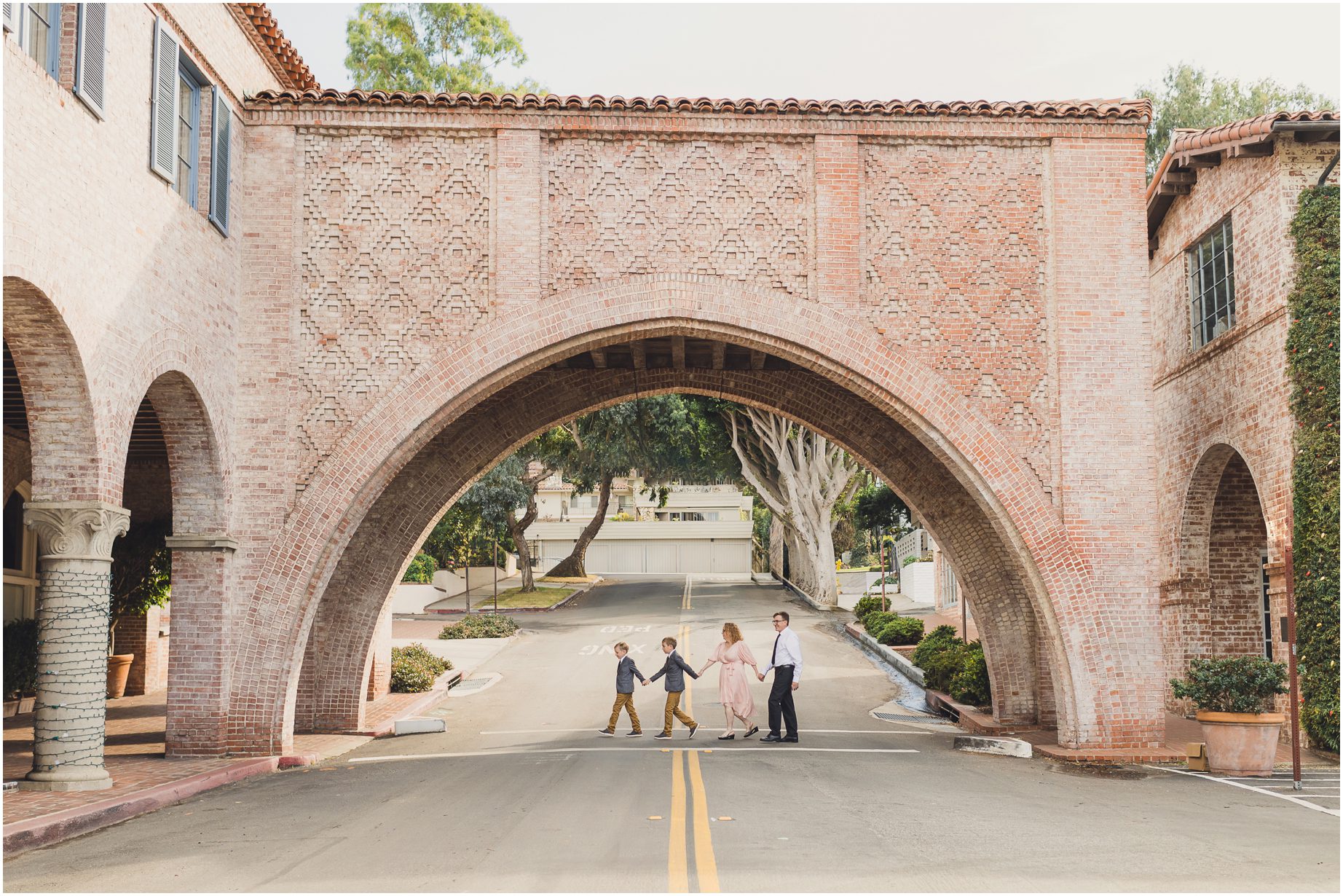 A family walks under an arch on a street in Palos Verdes California