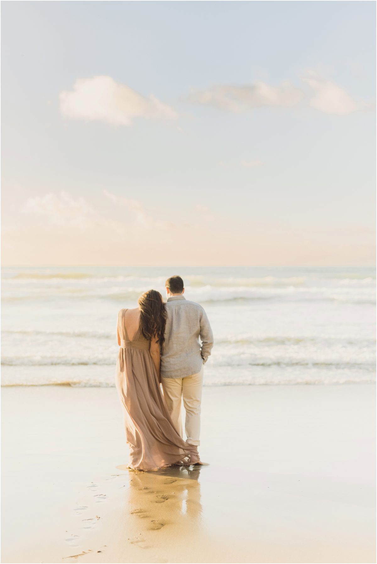 A couple looks out at the beach during their engagement session in Redondo Beach California
