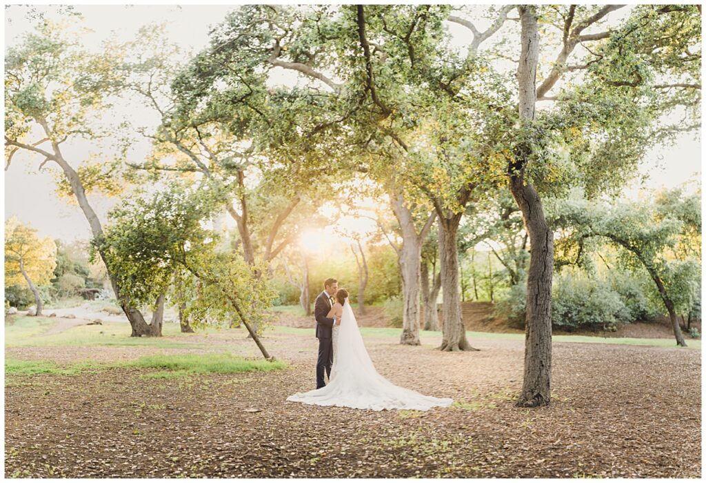 A bride and Groom stand in an oak forest representing our Wedding Photography FAQ