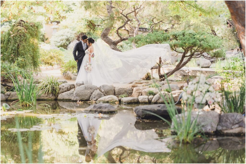 A Bride and Groom Pose for Couples portraits during their wedding at Storrier Stearns Japanese Garden