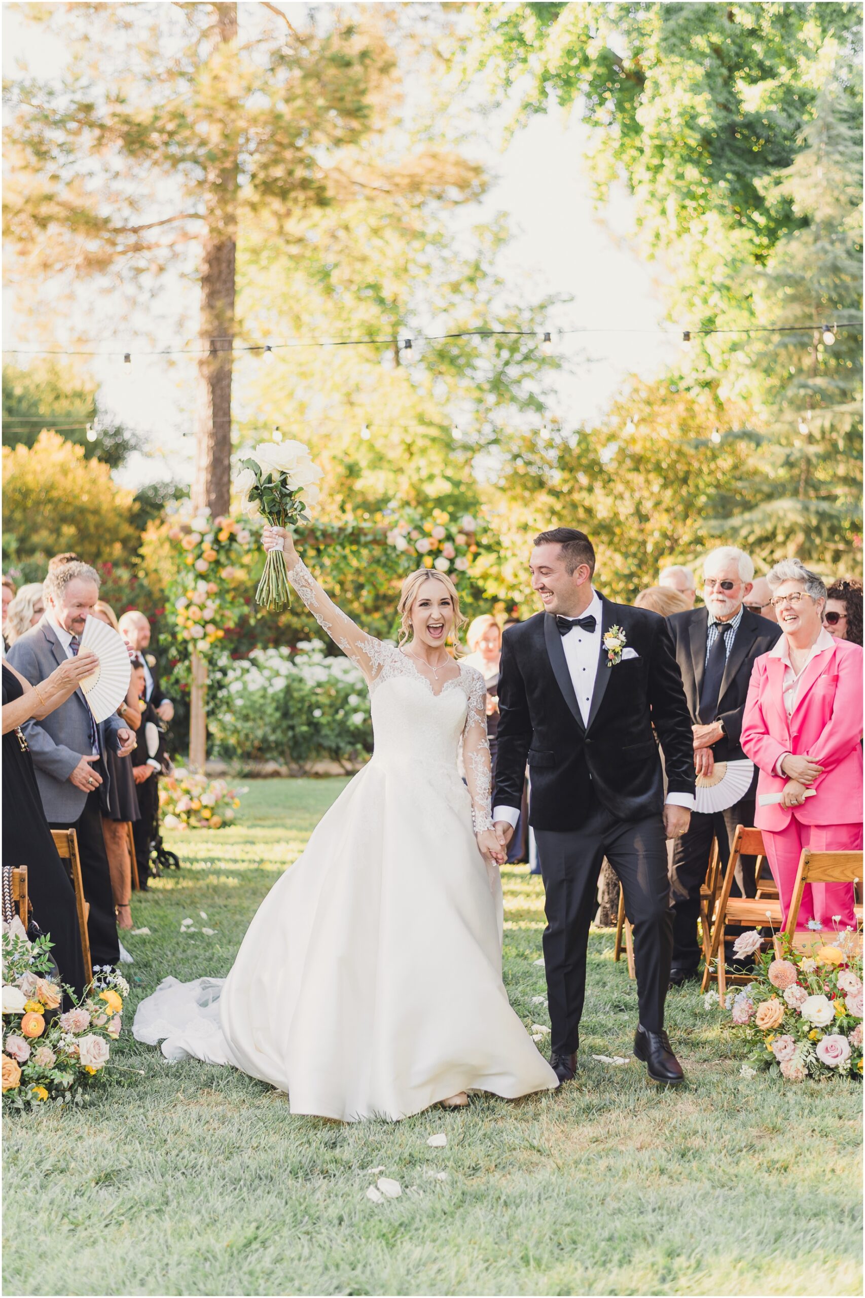 A bride and groom walk out of their ceremony at Malibou Lake Lodge. This Malibu Wedding was Photographed by Sun and Sparrow