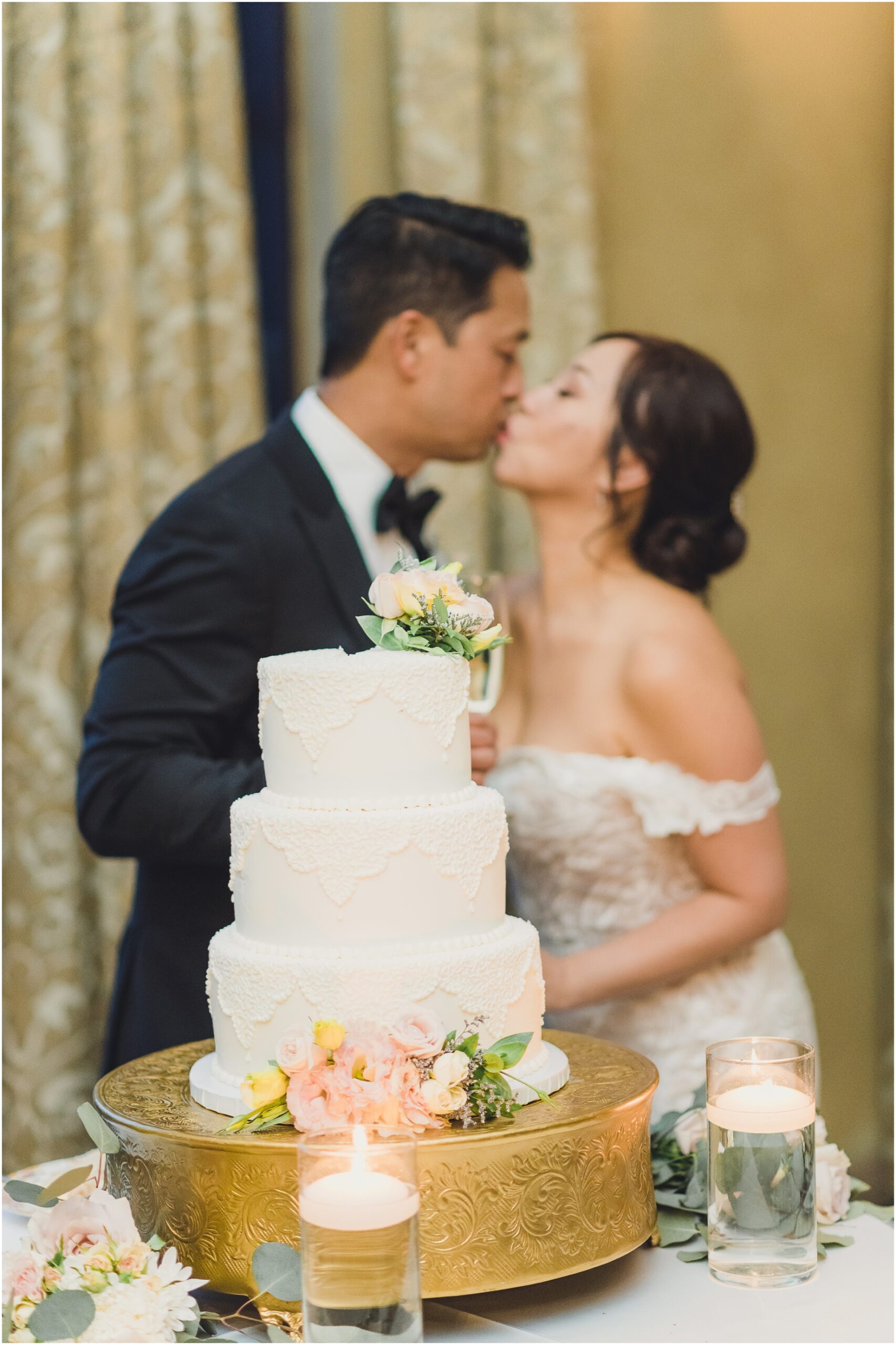 A couple kisses after they cut their wedding cake