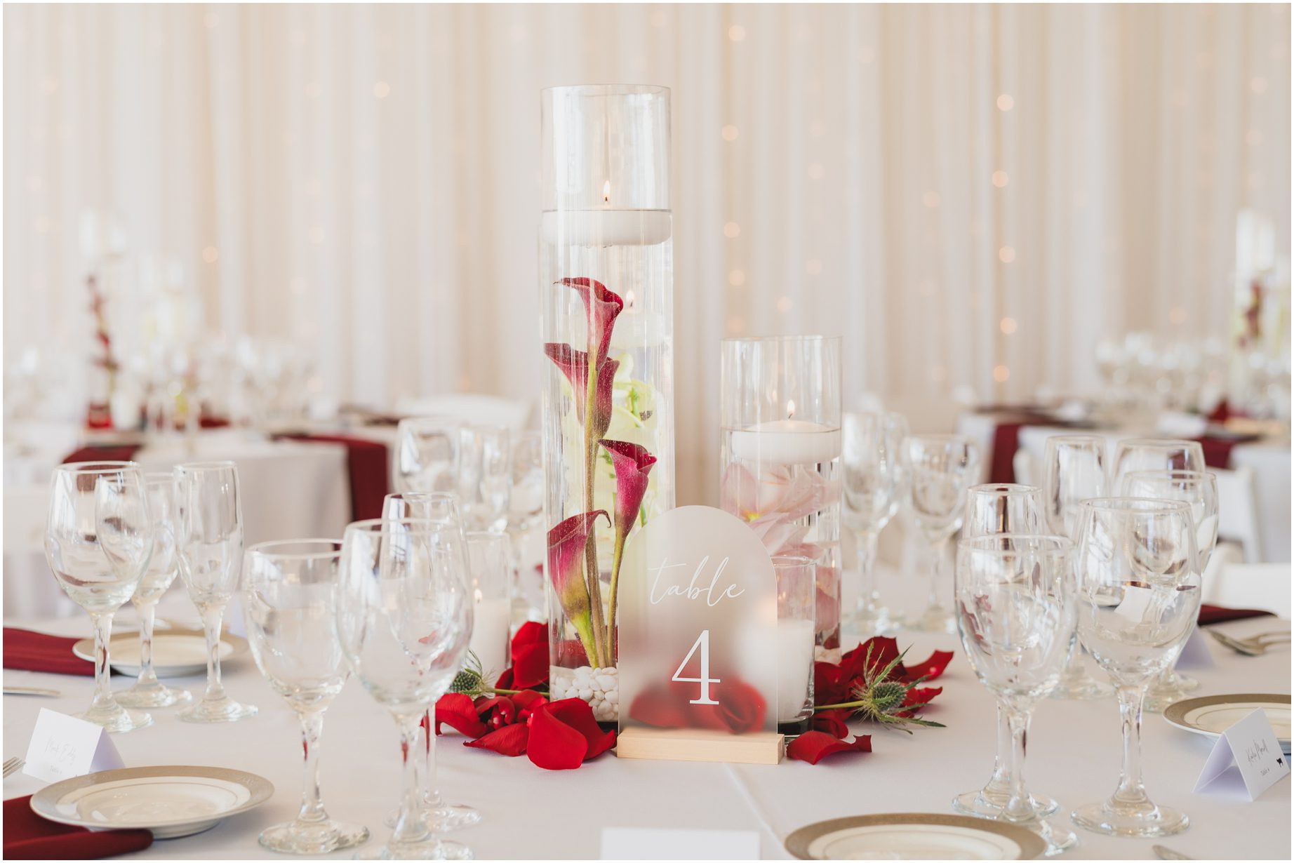 Wedding centerpiece featuring red flowers and white fabric at Malibu west beach club
