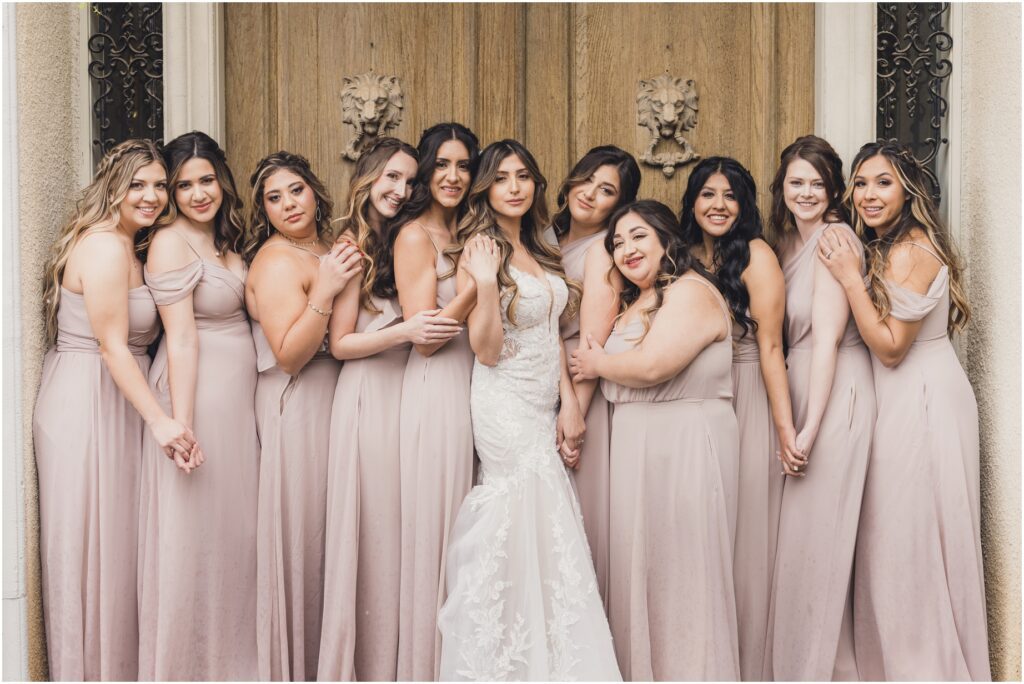 A bride and bridesmaids pose in front of a door at khyra beaucrest ranch