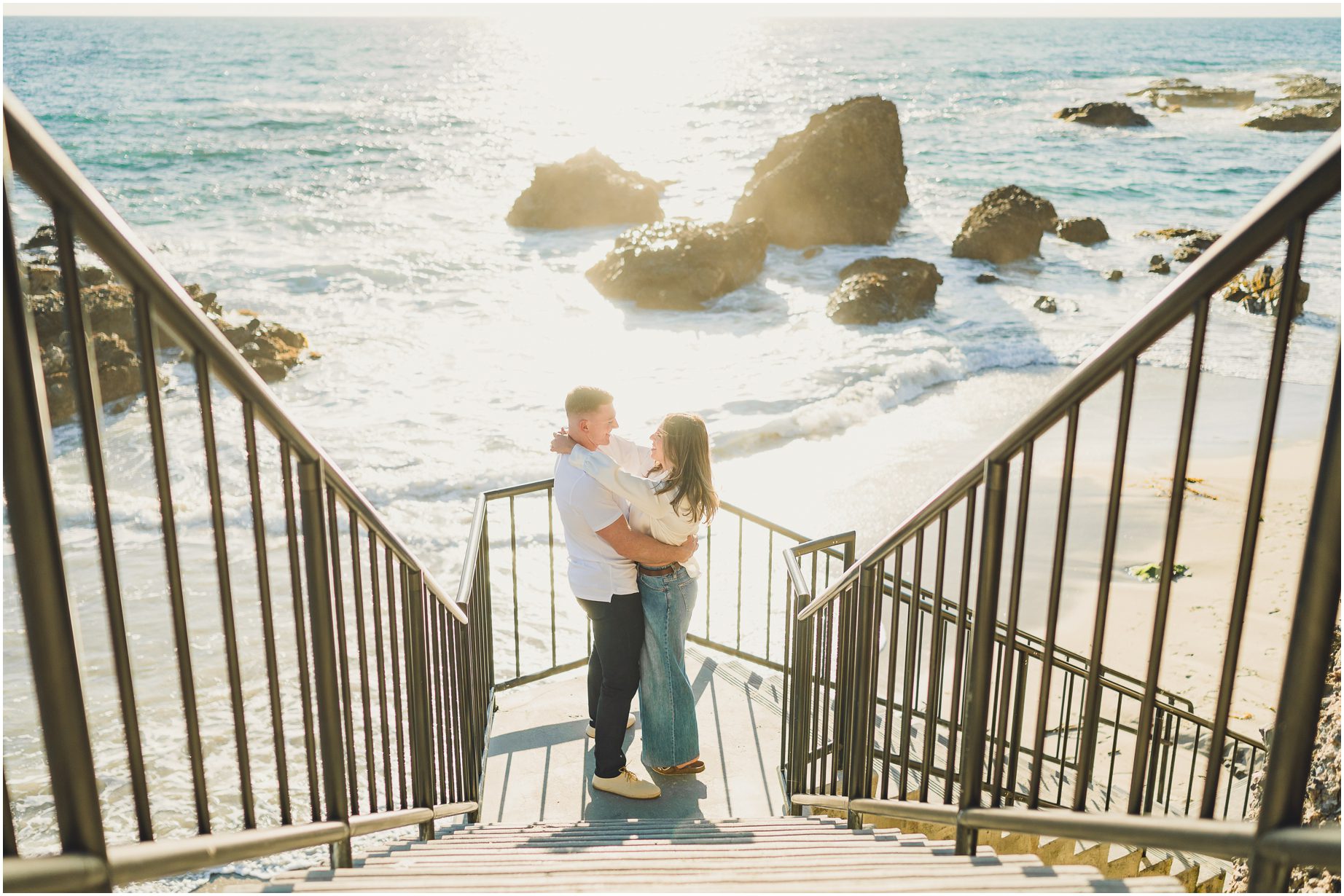 Bruce and Kendall hold each other on the stairs down to Woods Cove in Laguna Beach at sunset