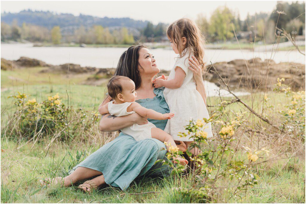 A mama holds her one year old in one arm while looking into her toddler's eyes, photographed by her Lake Oswego Family Photographer