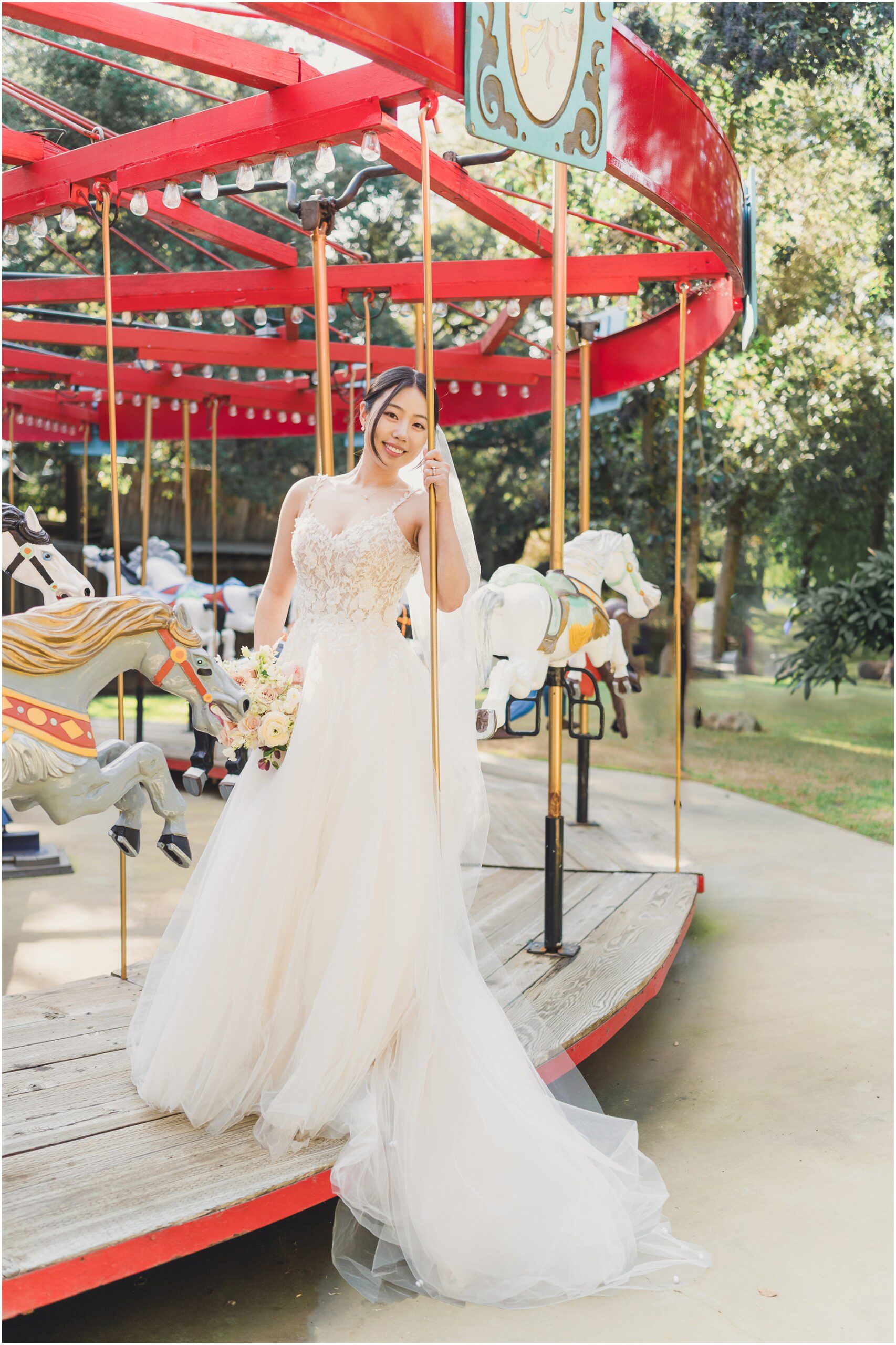 The bride at a Birchwood room wedding stands on a whimsical Carousel at Calamigos Ranch.