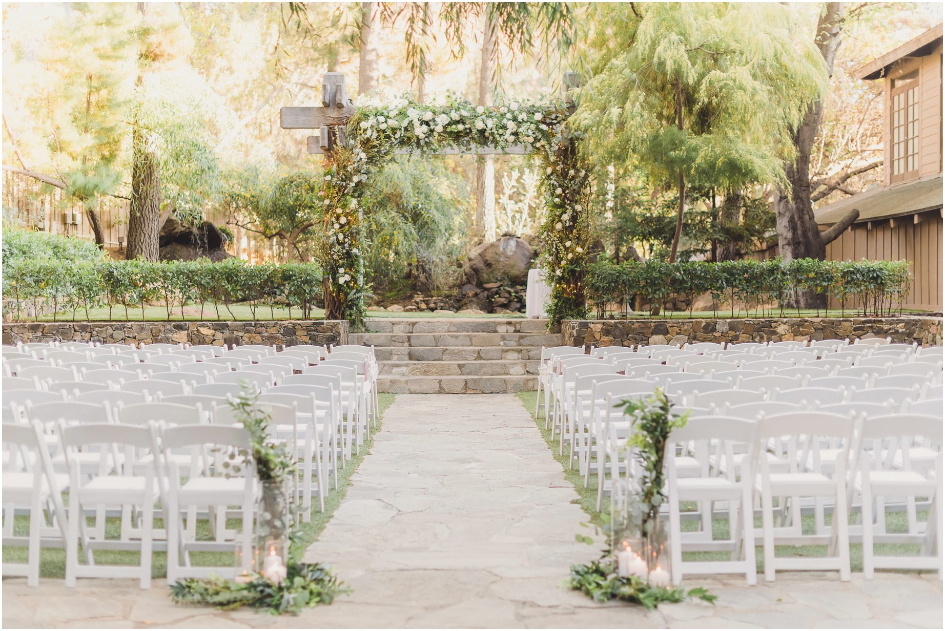 The luxurious ceremony space at the redwood room, featuring an ivy covered arch and white wedding chairs