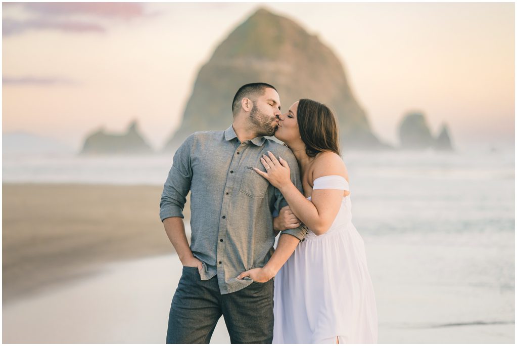 A couple kisses at Cannon Beach at the Oregon Coast