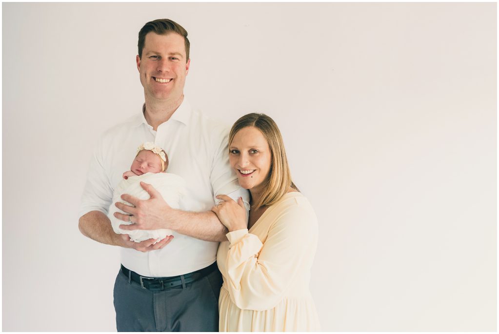young family holds baby